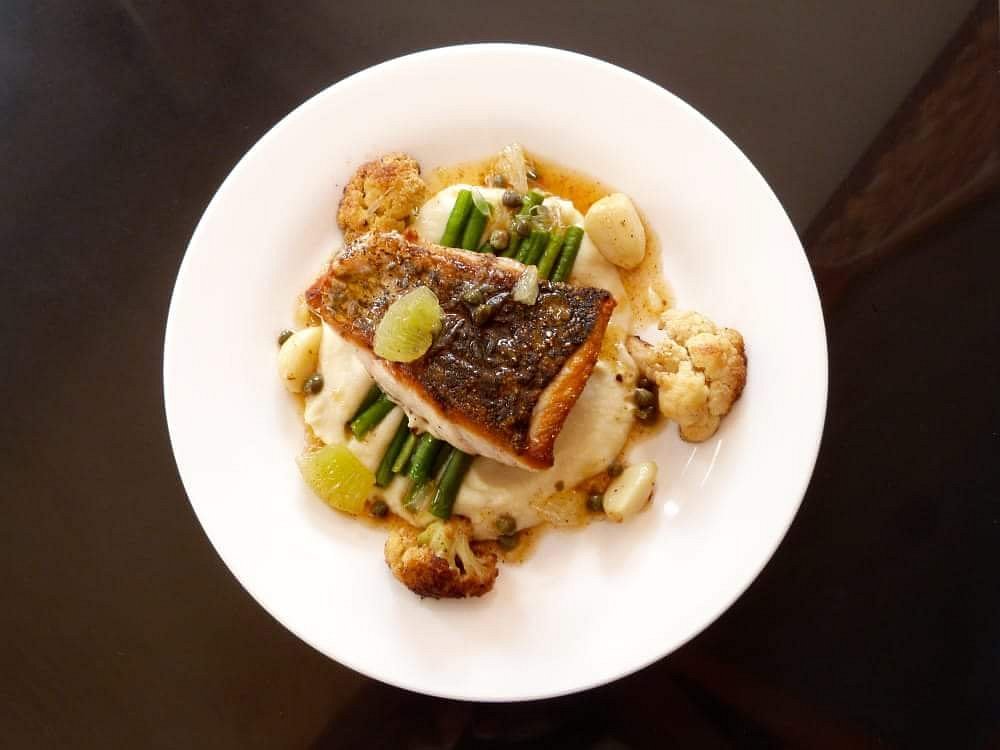 Bar rôti à la poêle, servi avec une purée de chou-fleur crémeuse